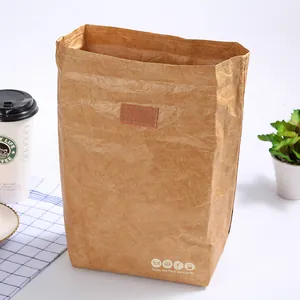Brown Tyvek insulated lunch bag with food icons on a white table with coffee and plants