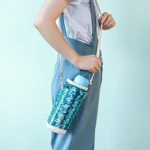 Dettaglio porta borraccia in paillettes con tracolla e tessuto glitterato blu
