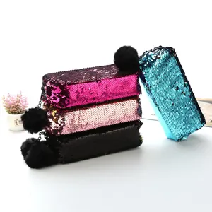 Détail de trousses à paillettes scintillantes multicolores avec pompons en peluche