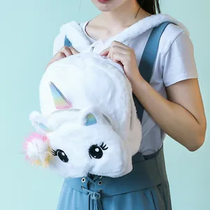 Detail of white plush unicorn backpack with colorful horn and soft faux fur texture