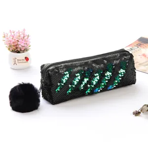Détail d'une pochette à paillettes sirène noire avec rayures bleues et pompon doux