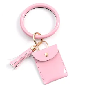 Pink patent leather keyring set featuring large wristlet, tassel, and snap wallet pouch