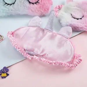 Detail of unicorn plush eye mask showing the pink satin back and elastic headband