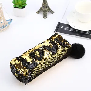 Détail de la trousse à paillettes avec motif LOVE et breloque pompon en peluche noire