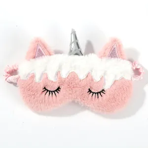 Detailed macro shot of soft pink unicorn plush sleep mask with silver horn and satin strap