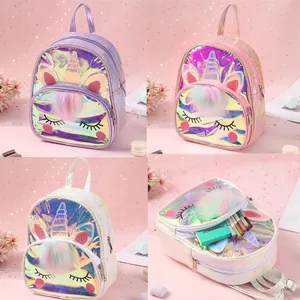 Close-up of glittery unicorn ears and colorful plush pompom details on a girl's backpack