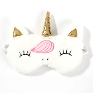Detail of white plush unicorn sleep mask with golden horn and soft faux fur texture