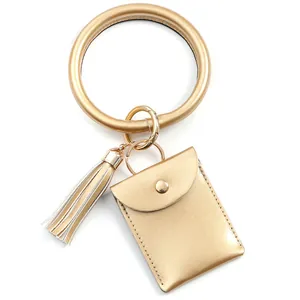 Detail of gold PU leather wristlet keychain with matching card holder and tassel charm