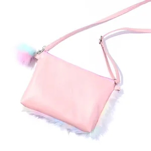 Detail of plush rainbow crossbody bag with pink strap and colorful pom-pom charm