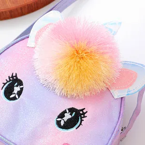 Close-up of glitter girls purse with eyelash embroidery and soft colorful faux fur pom