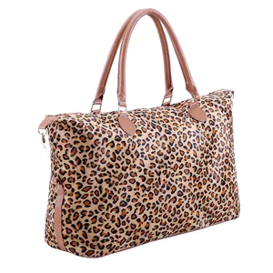 Détail du sac de voyage imprimé léopard avec anses en cuir marron et fermeture éclair