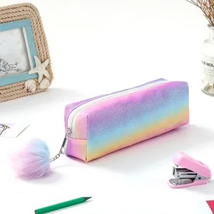 Close-up of rainbow glitter pencil case with colorful pom-pom and stationery accessories
