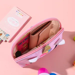 Detail of pink unicorn pouch showing interior storage for wallet and cute stationery