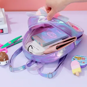 Internal storage detail of purple unicorn backpack with glitter wings and stationery items