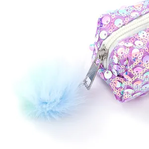 Dettaglio della pochette di paillettes viola con zip in metallo e pompon in pelliccia blu