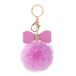 Detailansicht eines rosa flauschigen Bommel-Schlüsselanhängers mit Strassschleife