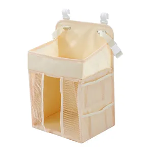 Detail view of beige hanging diaper organizer with breathable mesh pockets and hooks