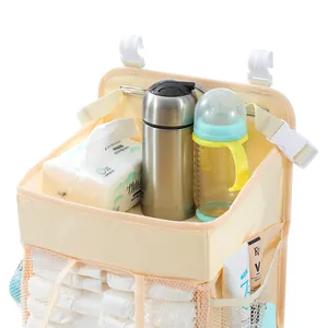 Detail of hanging diaper organizer with top tray and mesh side pockets for baby crib