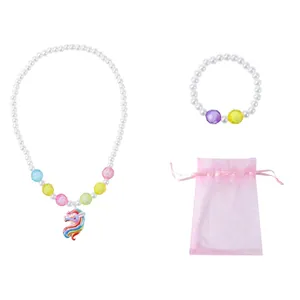 Nahaufnahme der Einhorn-Halskette mit Perlen und rosa Kordelzugbeutel aus Organza