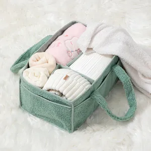 Detailed view of green fleece baby diaper caddy with multiple compartments and soft handles