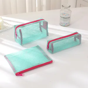 Detailed view of mint green mesh bag set with contrast pink zippers and nylon texture
