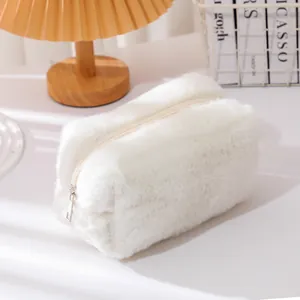 Close-up of a soft white plush makeup bag with a zipper on a cozy, minimalist desk