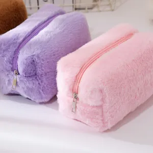 Close-up of soft plush makeup bags with silver zippers in lavender and pastel pink colors
