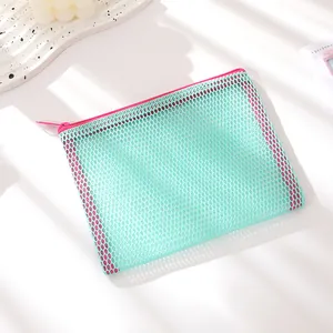 Détail du sac en maille vert menthe avec fermeture éclair rose et texture en nylon
