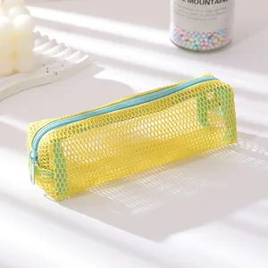 Detail of yellow mesh pencil case with light blue zipper on a minimalist sunlit desk