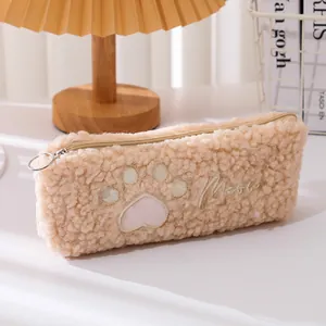 Detail van een pluche beige etui met kattenpoot borduursel en geborduurde Meow tekst