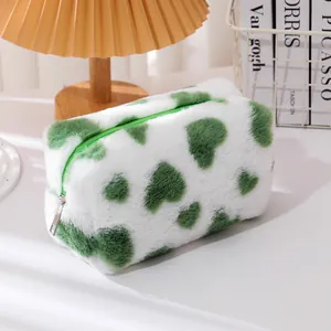 Detalle de neceser de peluche blanco con corazones verdes y textura muy suave