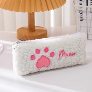 Detailopname van de witte pluche pennenzak met kattenpootborduurwerk en hartjespatroon