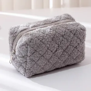 Minimalist grey plush makeup bag with quilted diamond pattern and zipper closure