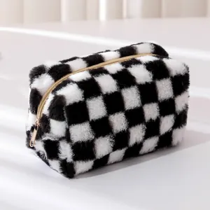 Close-up of black and white checkerboard plush pencil case with gold zipper detail