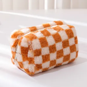 Detail of soft plush checkerboard pouch with smooth zipper and orange furry texture