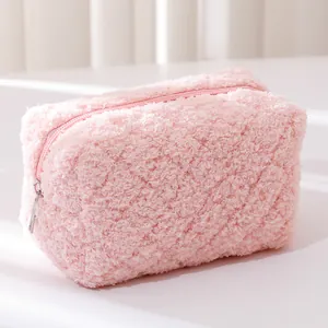 Close-up of pink plush pencil case with soft grainy texture and silver metal zipper detail