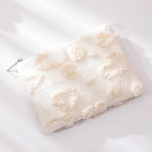 Dettaglio della borsa trucco bianca in peluche con texture a forma di cuore soffice