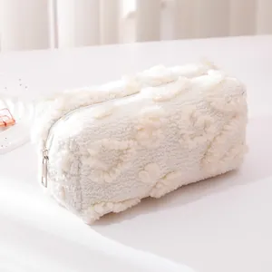 Macro detail of plush white pencil case featuring soft heart patterns and metal zipper