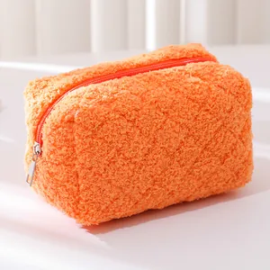 Close-up of bright orange plush pencil case with soft faux fur texture and silver zipper