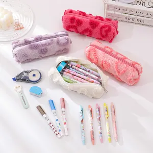 Detail showing plush texture and heart embossed patterns on soft candy-colored pencil cases