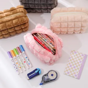 Primer plano de estuches de felpa acolchados en varios colores con artículos de papelería
