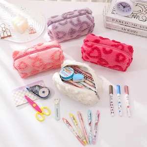 Detailed view of colorful plush heart-patterned pencil cases with stationery items