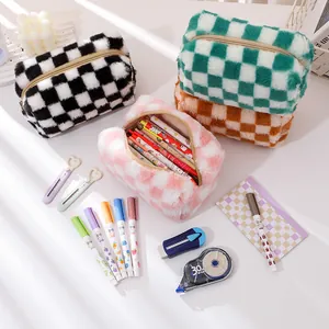 Macro shot of checkered plush pouch with gold zipper showing large capacity for pens