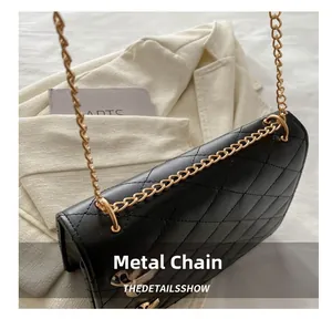 Détail de la chaîne dorée sur un sac bandoulière en cuir noir matelassé élégant