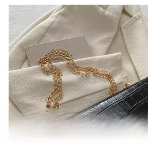 Detail der schwarzen Umhängetasche in Krokoprägung mit goldener Kette und S-Logo-Schnalle