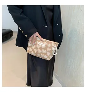 Detail view of oatmeal cosmetic bag with white hearts and elegant pearl handle