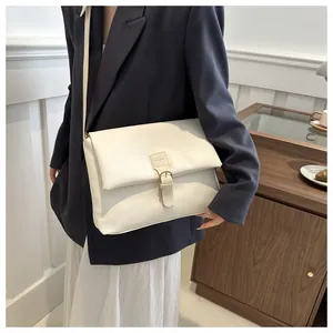 Détail du sac fourre-tout en cuir PU blanc crème avec rabat et bandoulière sur mannequin