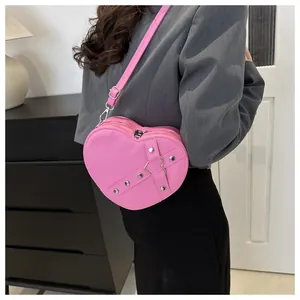 Detailansicht der pinkfarbenen Herz-Umhängetasche mit Metallnieten und Riemen