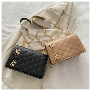 Détails des sacs matelassés noir et beige avec des nœuds métalliques dorés chic