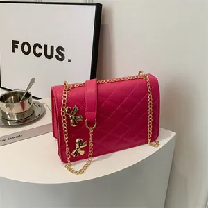 Petit sac à bandoulière rose fuchsia matelassé avec chaîne et nœuds dorés